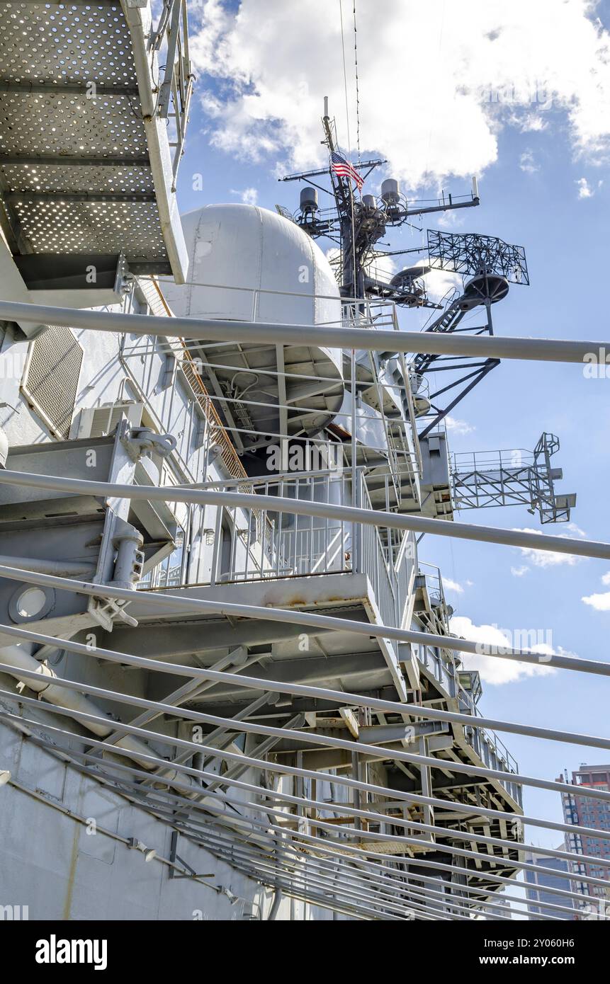 Guardando fino alla Torre della nave Intrepid, Intrepid Sea-Air-Space Museum, costruzione di acciaio di fronte, New York City durante la soleggiata giornata invernale, verti Foto Stock