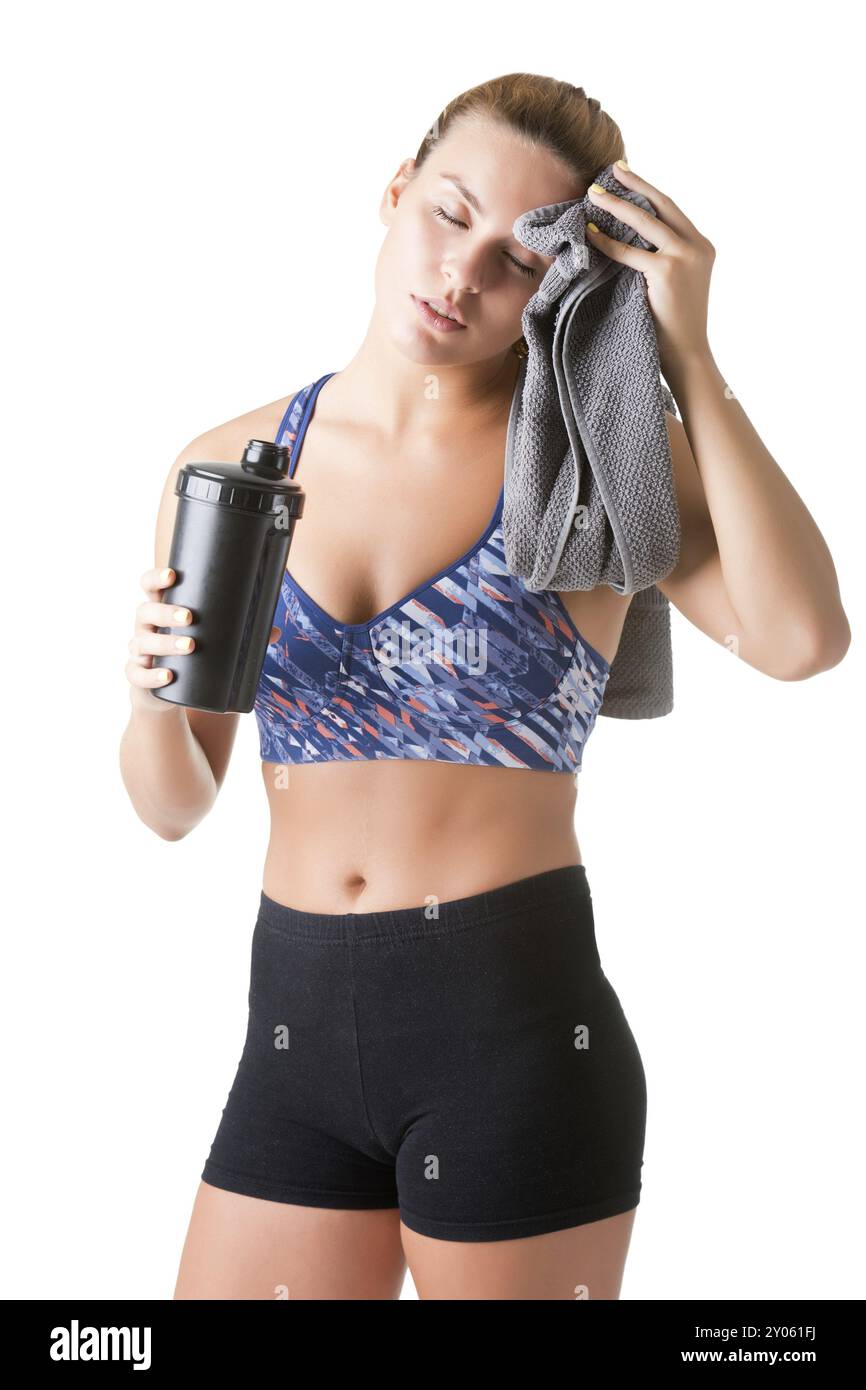 Donna in appoggio con un asciugamano attorno al collo dopo un allenamento fitness, isolato in bianco Foto Stock