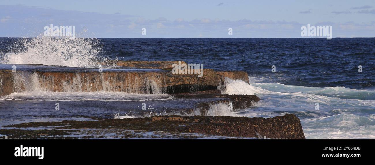 Onde che si tuffano sulle rocce vicino a Maroubra Beach, Sydney Foto Stock
