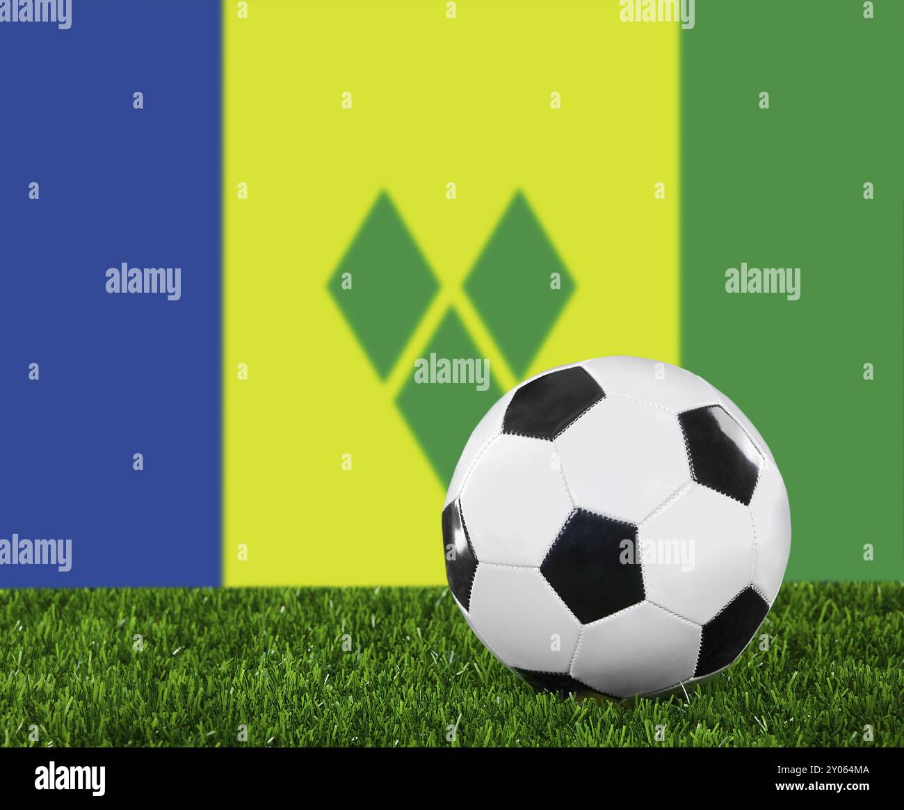La bandiera di Saint Vincent e Grenadine e il pallone da calcio sull'erba verde Foto Stock