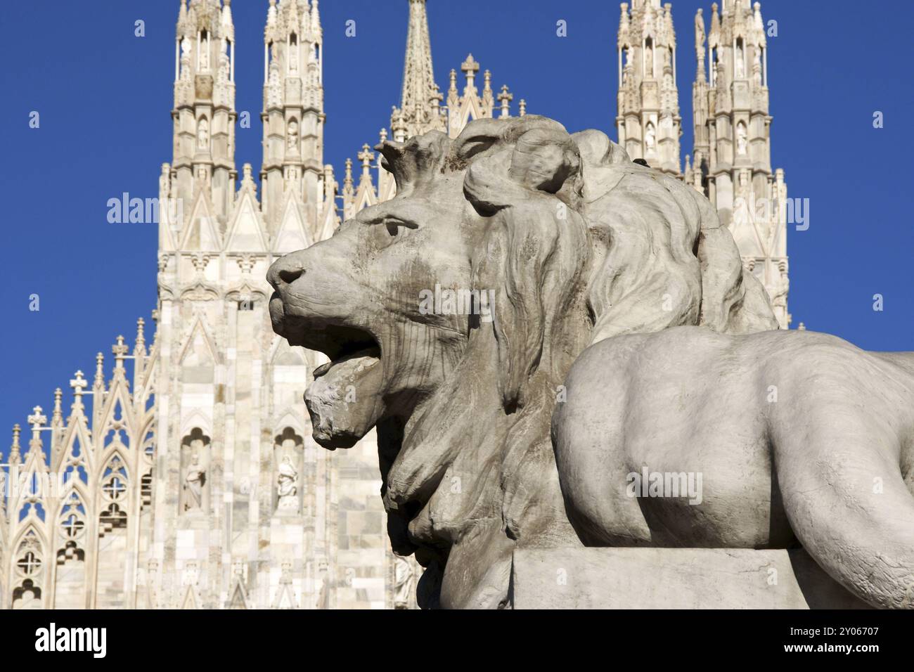 Leone di pietra dal seminterrato del monumento a Re Vittorio Emanuele il secondo di fronte alla facciata gotica del Duomo di Milano in Piazza Duomo Foto Stock