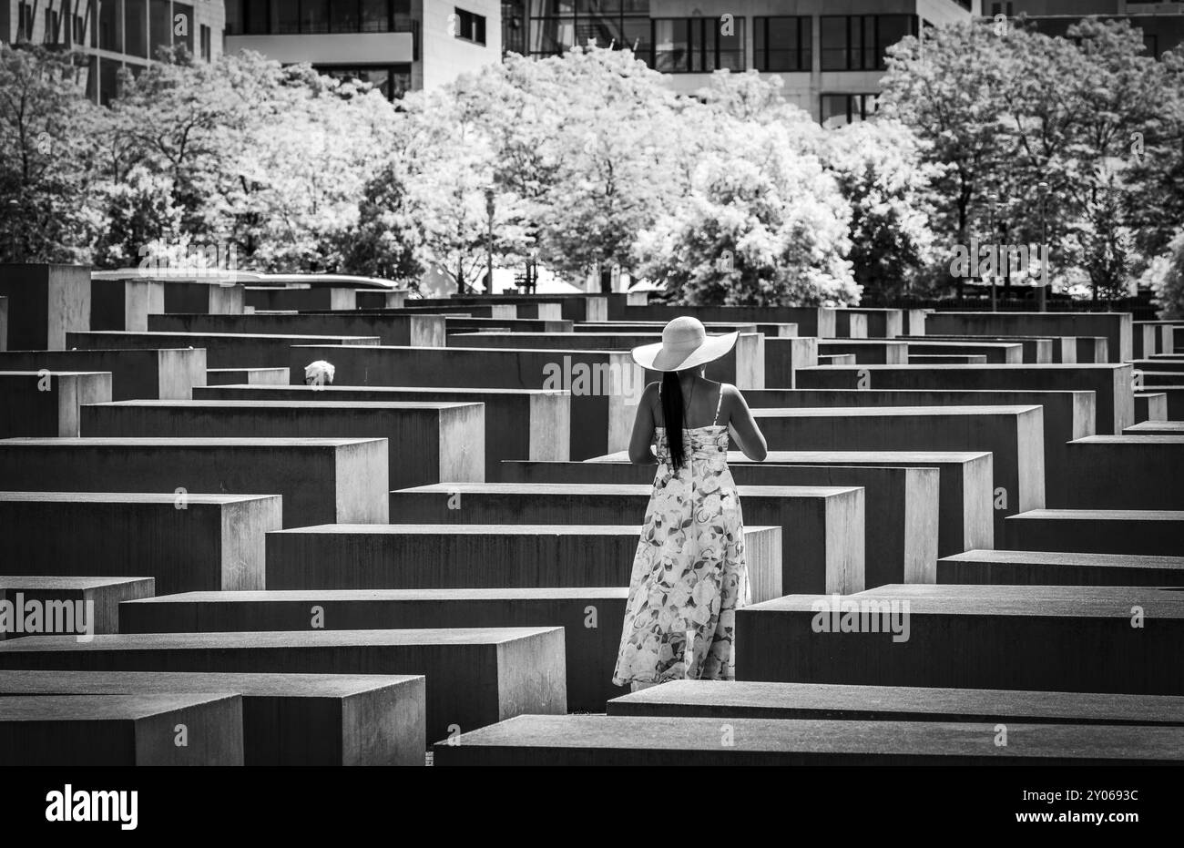 Fotografia in bianco e nero, donna in abito estivo tra le stele commemorative dell'Olocausto al Brandenburg Tor, Berlino, Germania, Europa Foto Stock