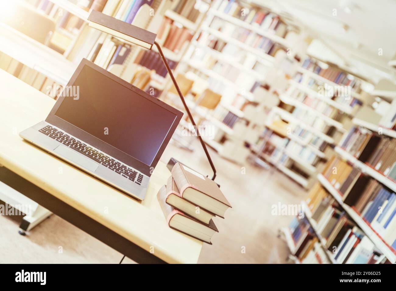 Laptop e una pila di libri su un tavolo di legno. Biblioteca universitaria Foto Stock