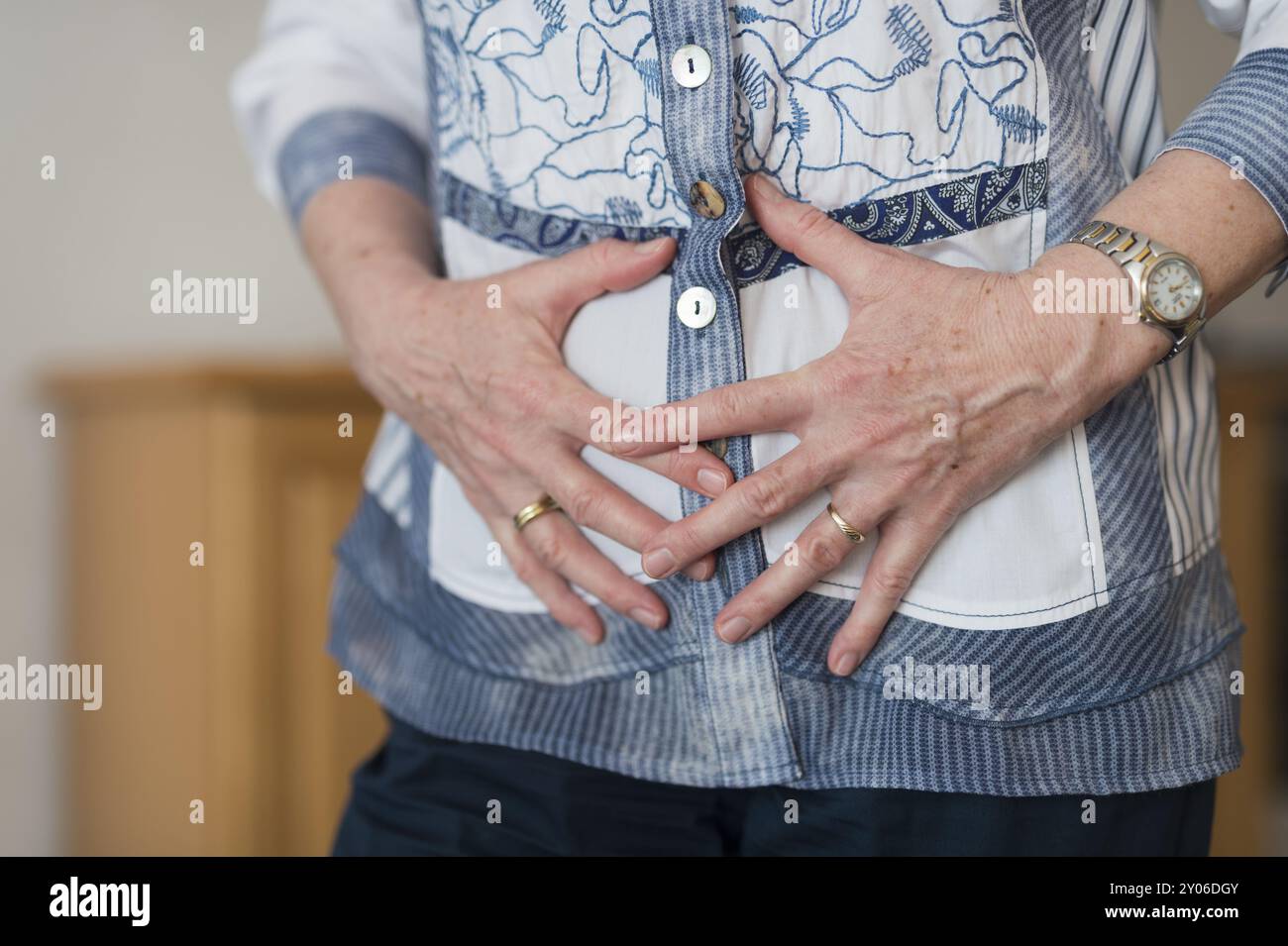 Le mani di una donna si sono agganciate davanti allo stomaco Foto Stock