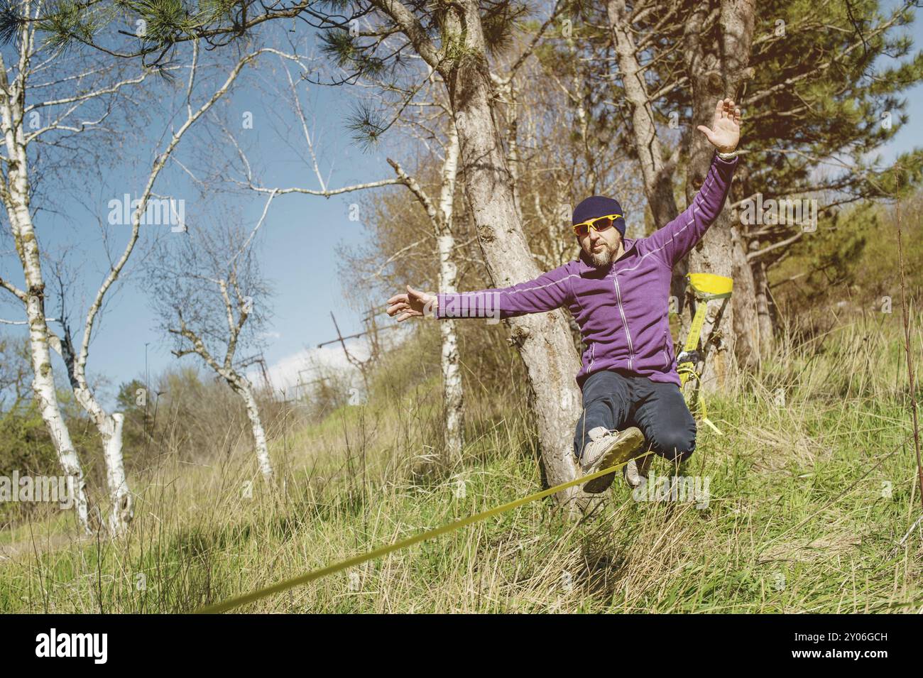 Un uomo all'età di sedersi su una linea lenta, trovare equilibrio e godersi la vita Foto Stock