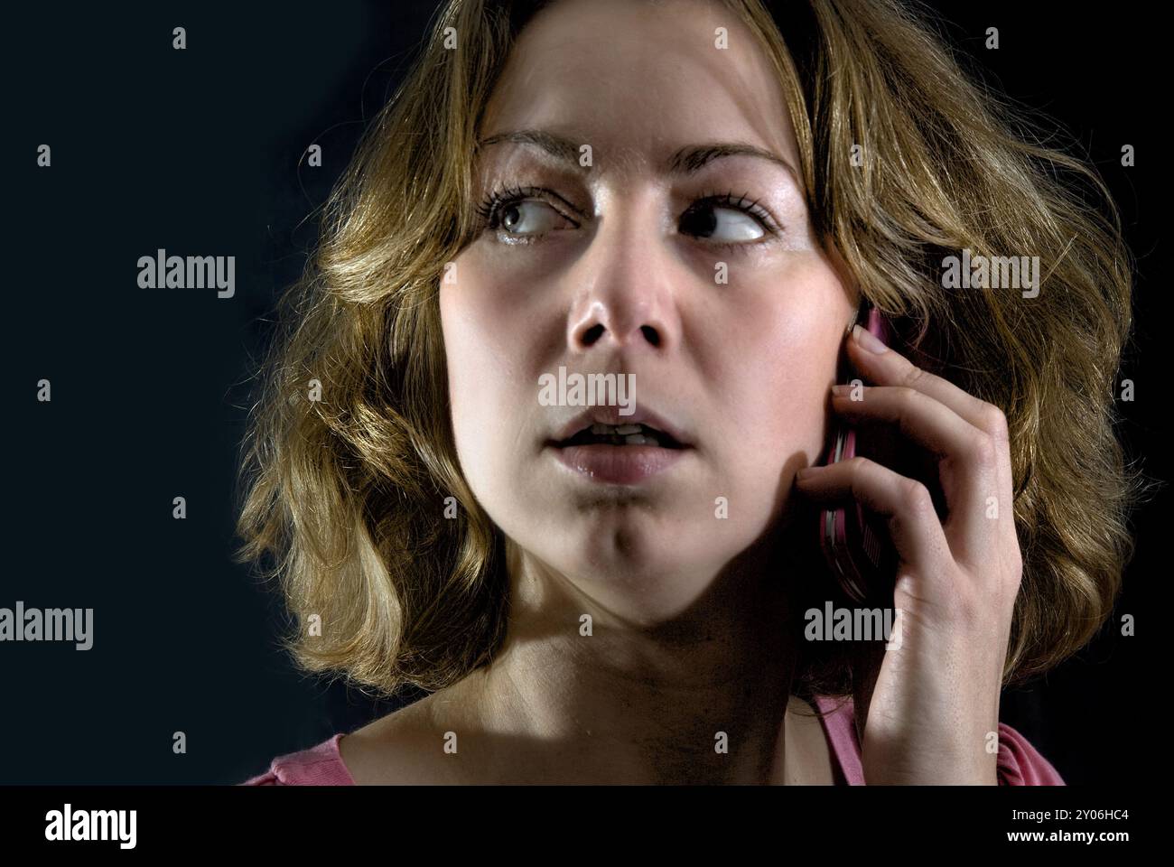 Giovane donna al telefono al buio Foto Stock