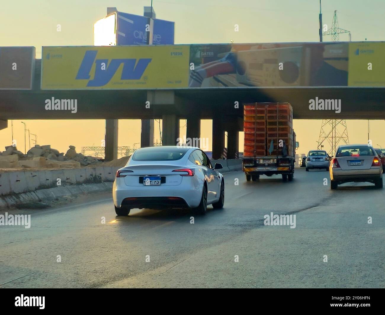 Giza, Egitto, 9 agosto 2024: White Tesla Car on the Road, Tesla, Inc. È una multinazionale americana nel settore automobilistico e dell'energia pulita con sede in Foto Stock