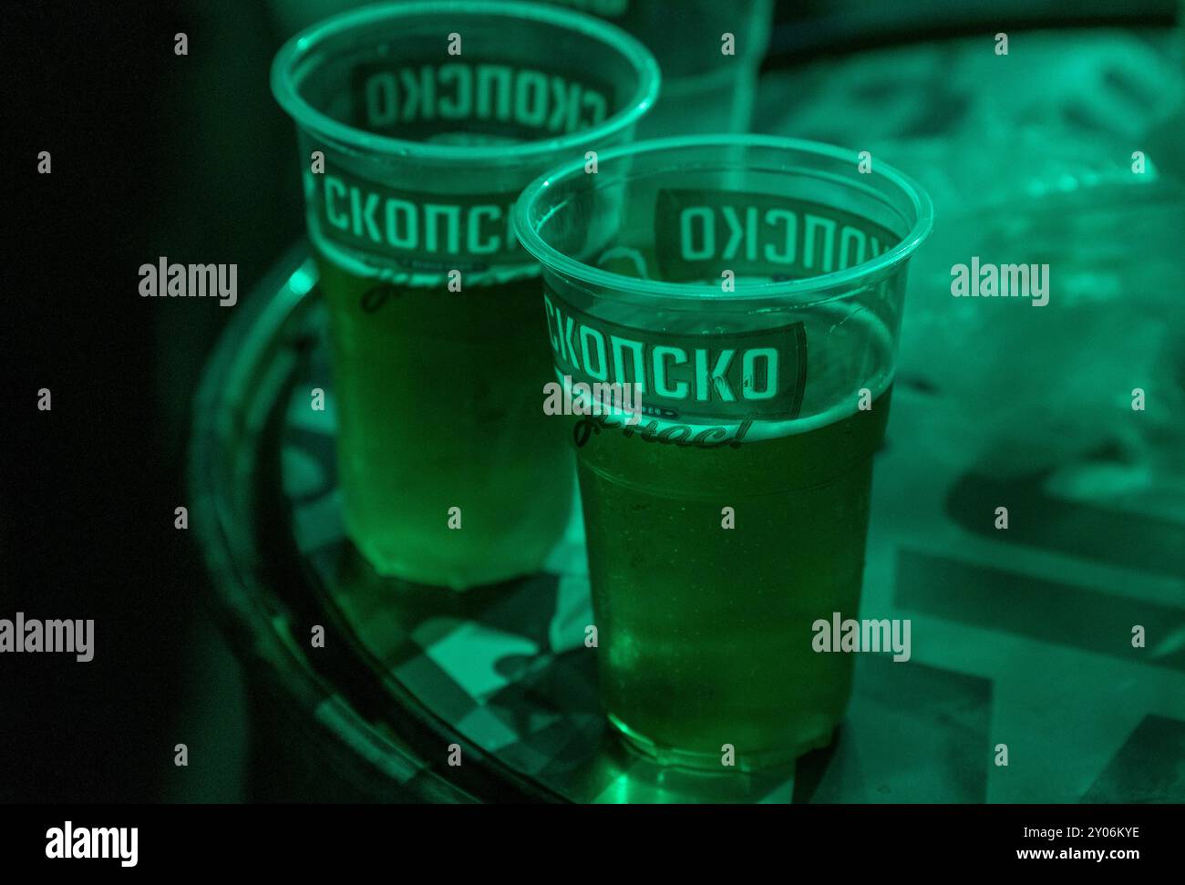 Migliore birra macedone: Skopsko Lager in tazze di plastica su una canna di metallo - Street Style Edition. 8. 26. 2024 Shtip Macedonia Foto Stock