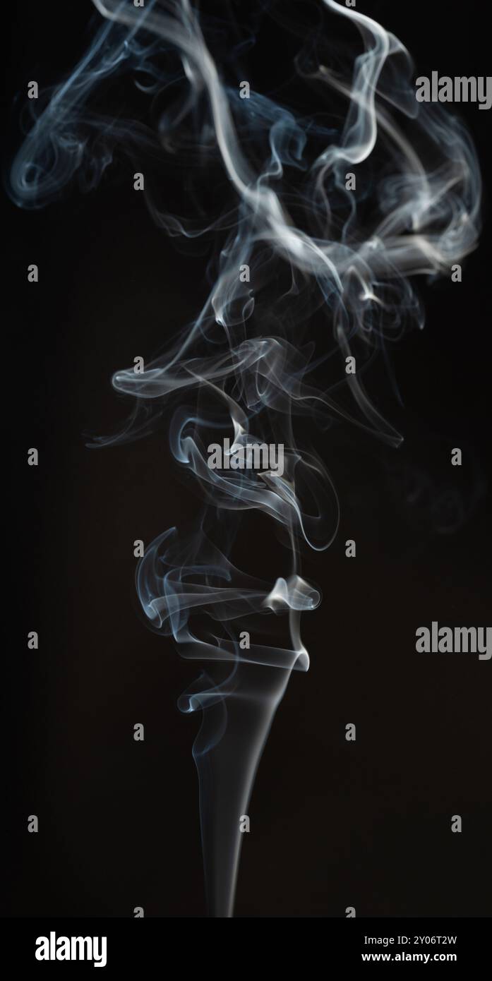 Arricciatura di fumo volante isolata su sfondo nero studio Foto Stock