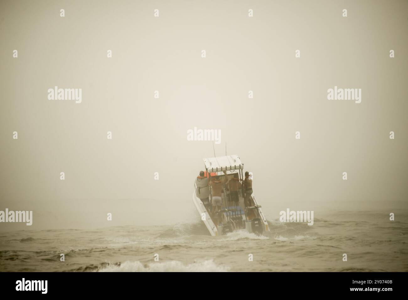 Una barca a motore per la pesca d'altura si lancia tra le onde e la nebbia Foto Stock