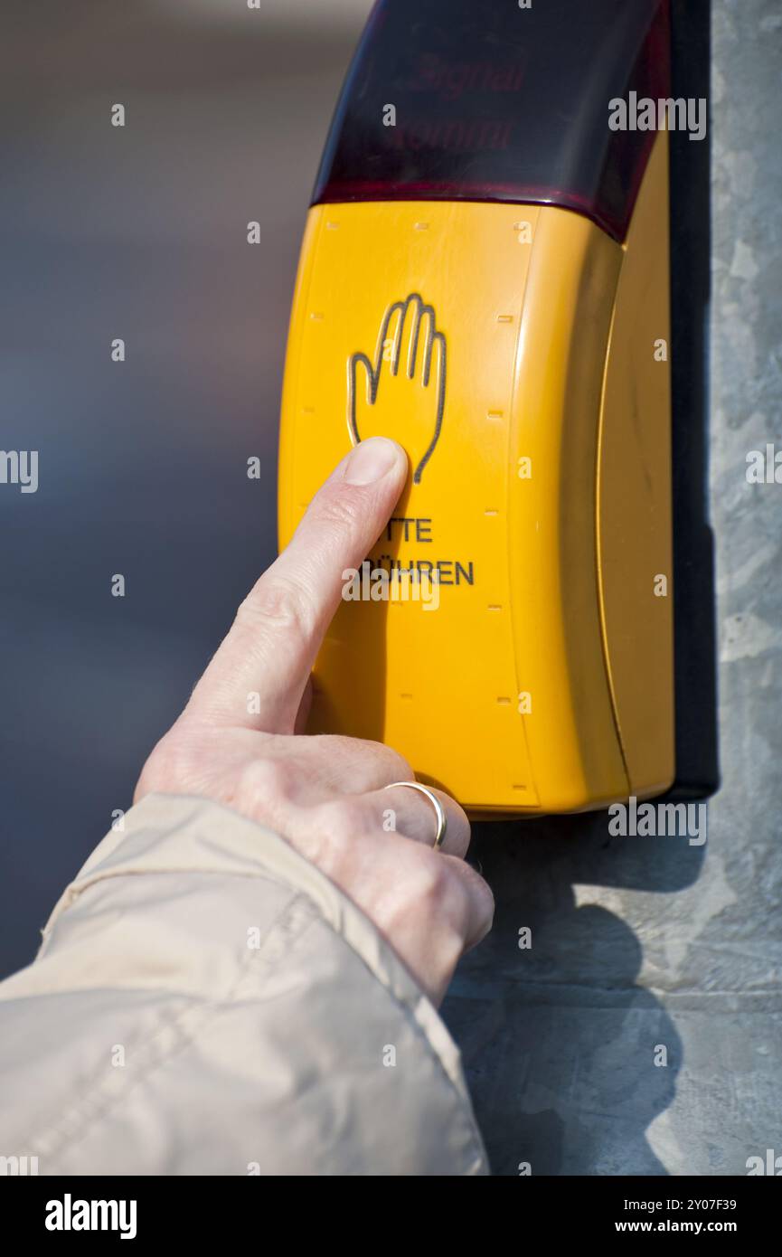 Dito indice allungato sul pulsante di un sistema a semaforo Foto Stock