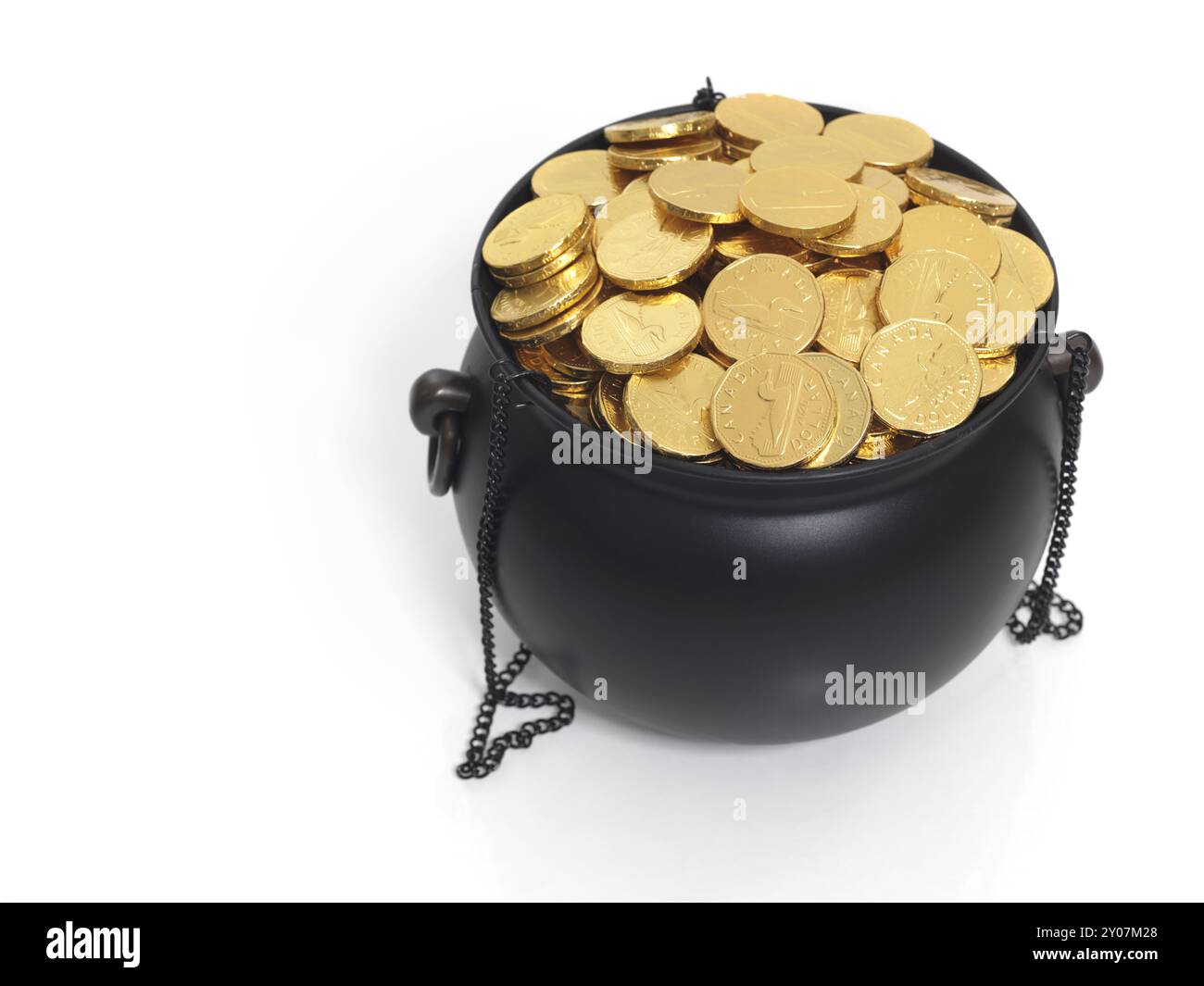 Cauldron pieno di soldi, finte monete d'oro. Isolato su bianco Foto Stock
