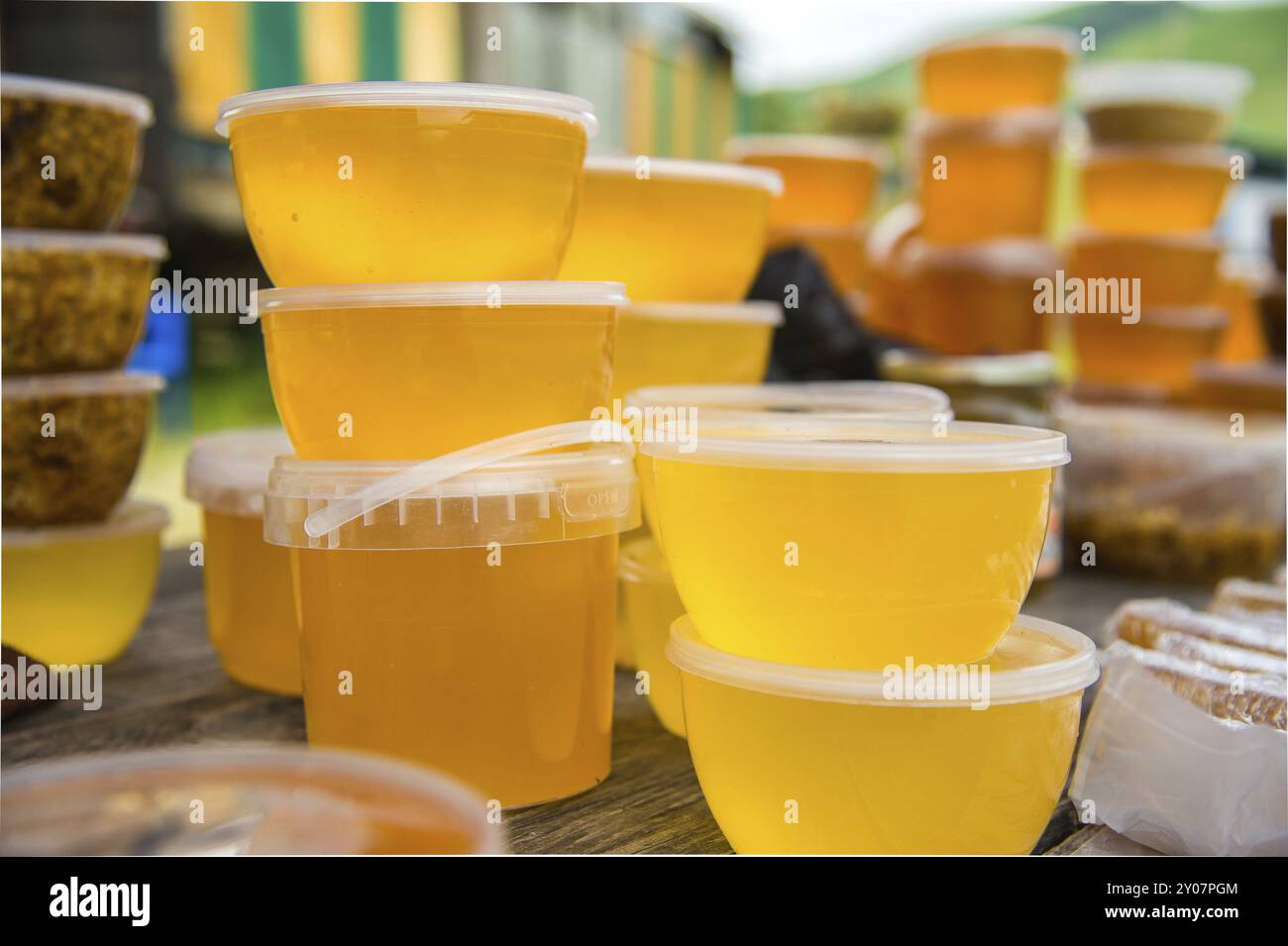 Vendita di miele all'aperto in vasetti di plastica Foto Stock