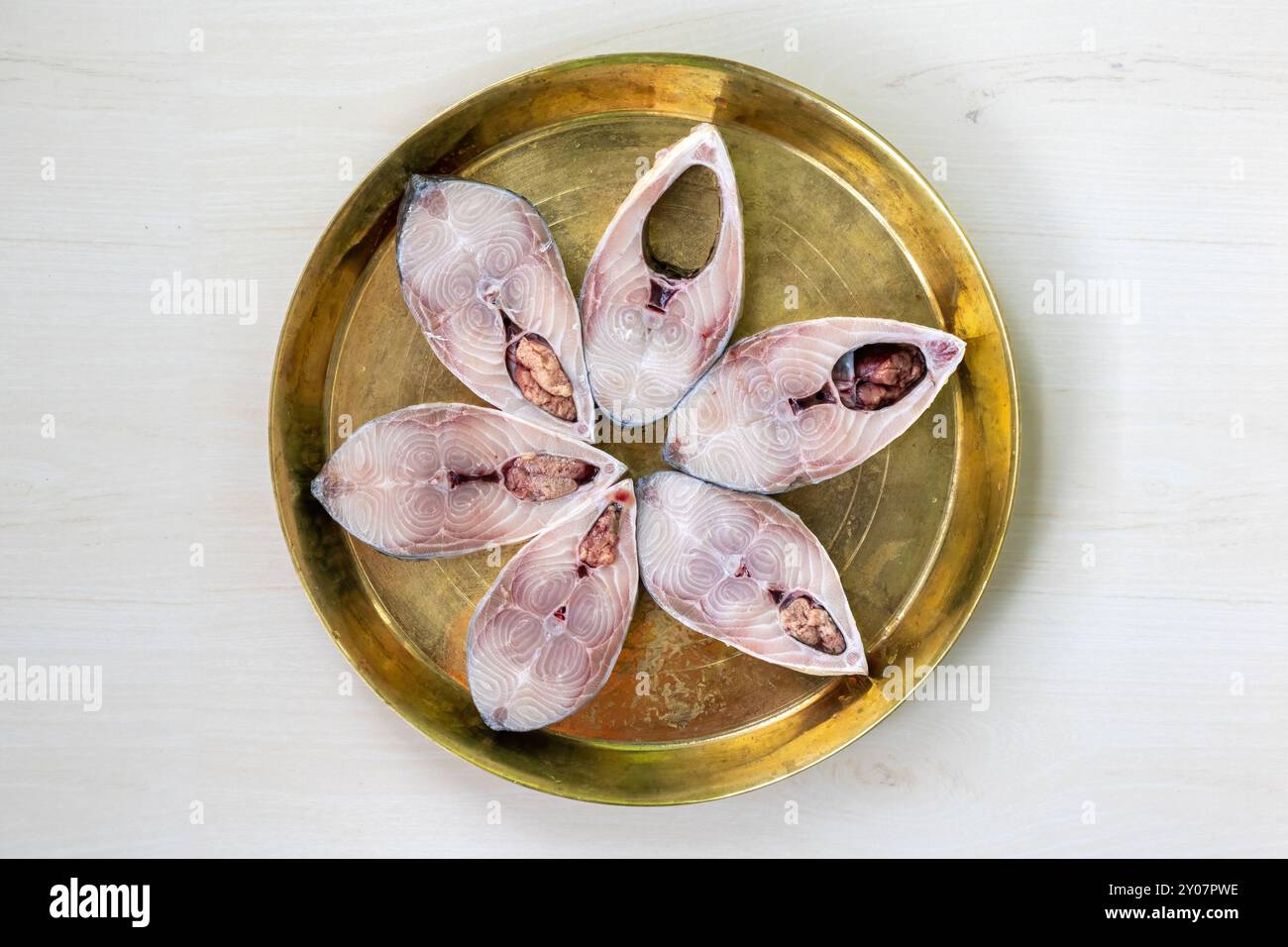 Fette di pesce fresco crudo hilsa su piatto di ottone, pronto per la cottura. Il famoso pesce ilish del fiume Padma in Bangladesh. Foto Stock