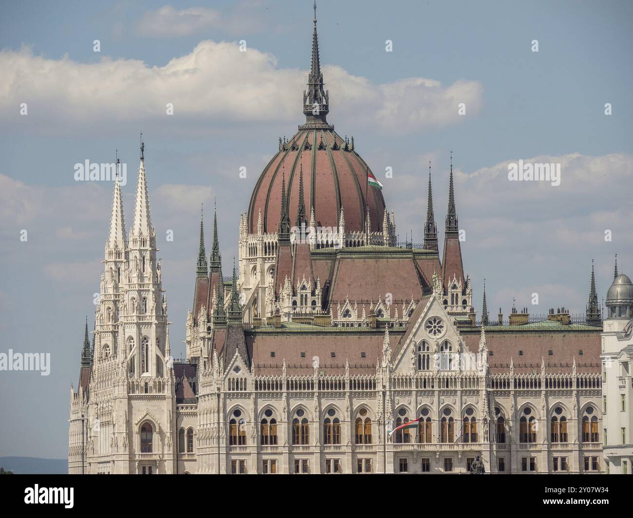 Edificio del parlamento neogotico con una suggestiva cupola e torri, sotto un cielo blu con nuvole bianche, budapest, danubio, ungheria Foto Stock