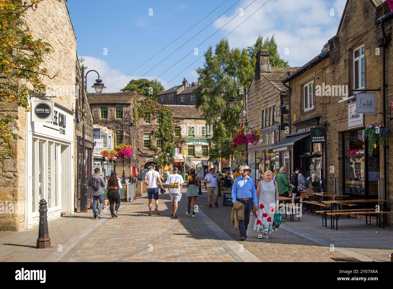 Gente che si gode il sole estivo nei bar e caffe' della citta' mercato del West Yorkshire di Hebden Bridge nella valle di Calderdale, Inghilterra Foto Stock