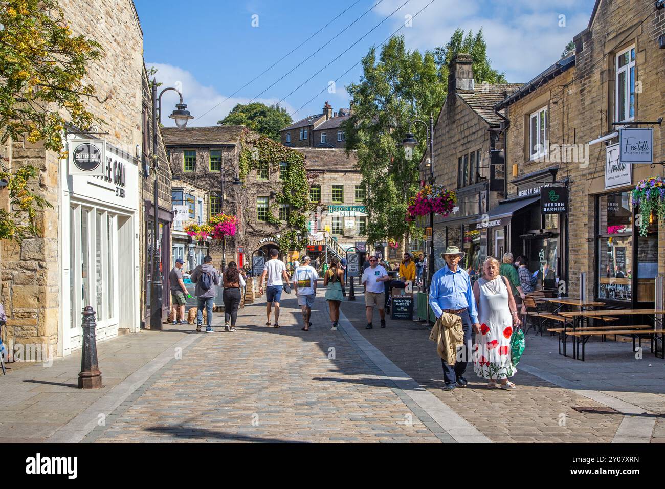 Gente che si gode il sole estivo nei bar e caffe' della citta' mercato del West Yorkshire di Hebden Bridge nella valle di Calderdale, Inghilterra Foto Stock