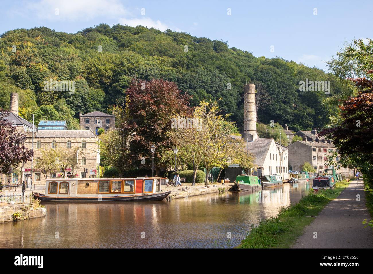 Le barche stretrowboats del canale ormeggiate dall'ex mulino Crossleys sul canale di Rochdale nella città di mercato di Calderdale Valley, Hebden Bridge, West Yorkshire, Inghilterra Foto Stock