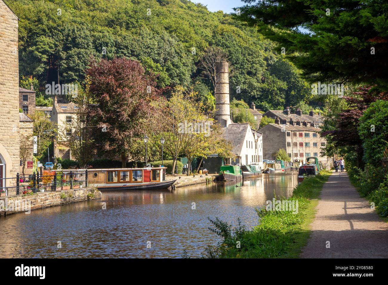 Le barche stretrowboats del canale ormeggiate dall'ex mulino Crossleys sul canale di Rochdale nella città di mercato di Calderdale Valley, Hebden Bridge, West Yorkshire, Inghilterra Foto Stock