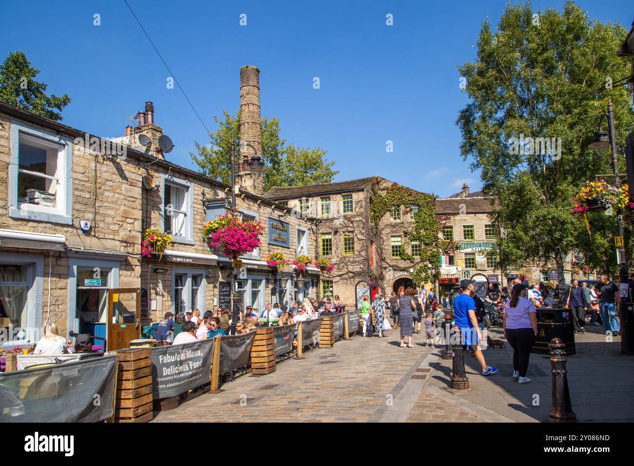 Gente che si gode il sole estivo nei bar e caffe' della citta' mercato del West Yorkshire di Hebden Bridge nella valle di Calderdale, Inghilterra Foto Stock