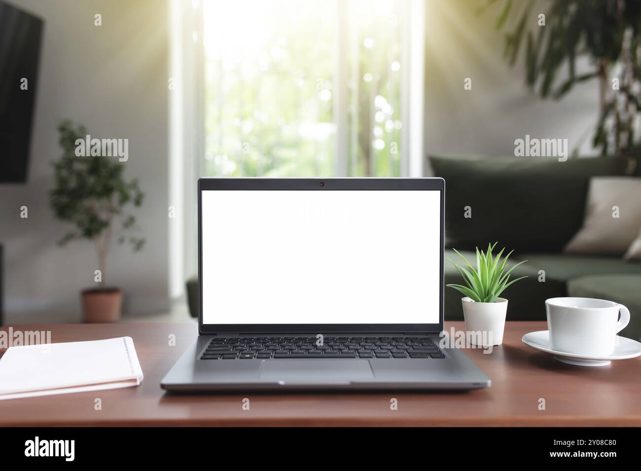 Lavoro da casa, spazio di lavoro, desktop, concetto di lavoro remoto, computer portatile grigio con schermo bianco vuoto mock-up su tavolo di legno marrone con tazza bianca di Foto Stock