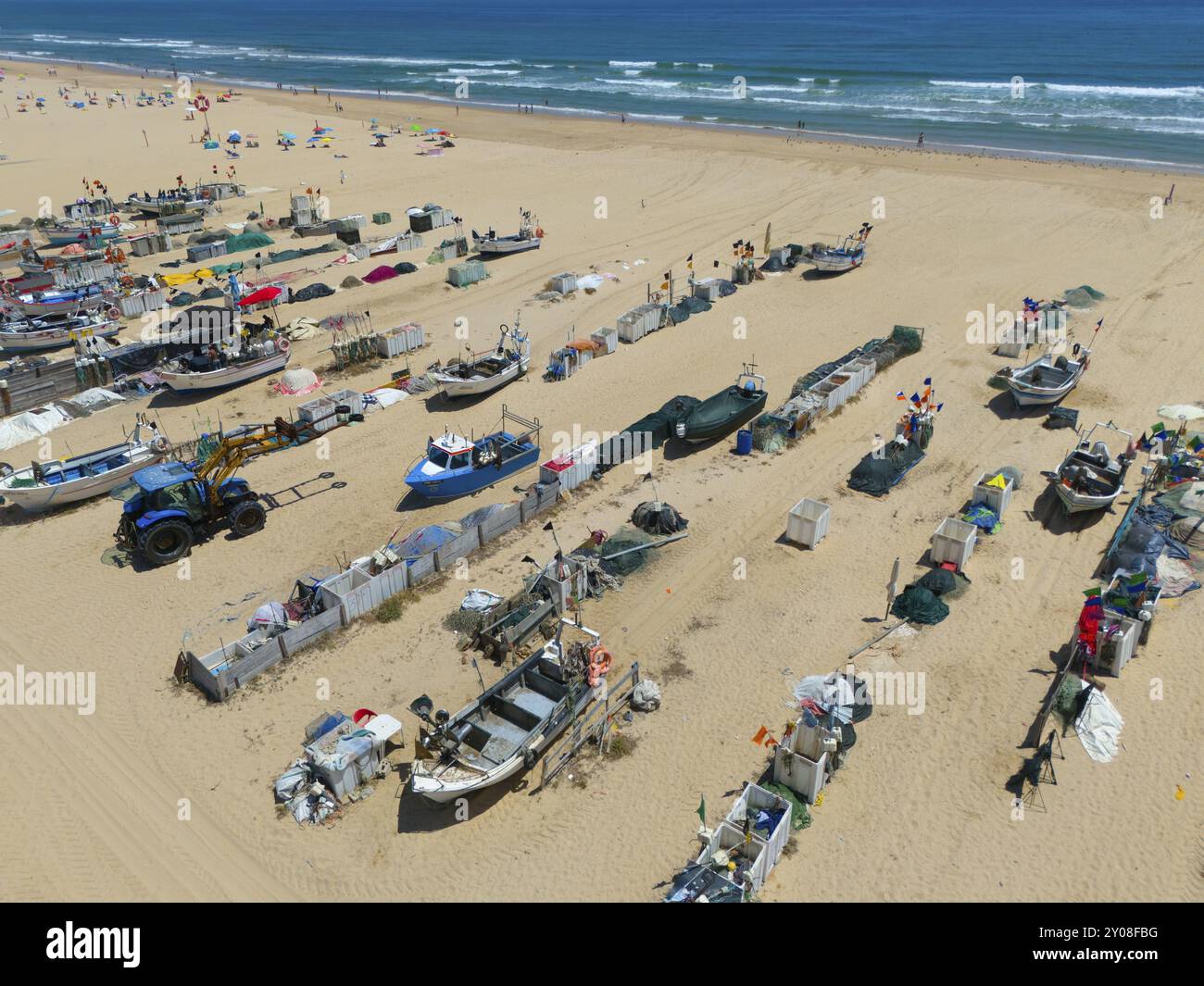 Barche da pesca e reti sulla spiaggia con vista sul mare e poche persone in lontananza, vista aerea, barche da pesca attraccate sulla spiaggia, M Foto Stock