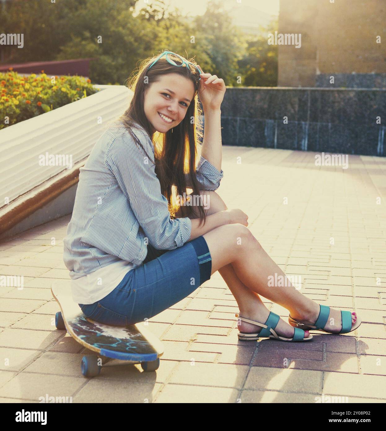 Teen girl su longboard sulla strada a bella serata estiva Foto Stock