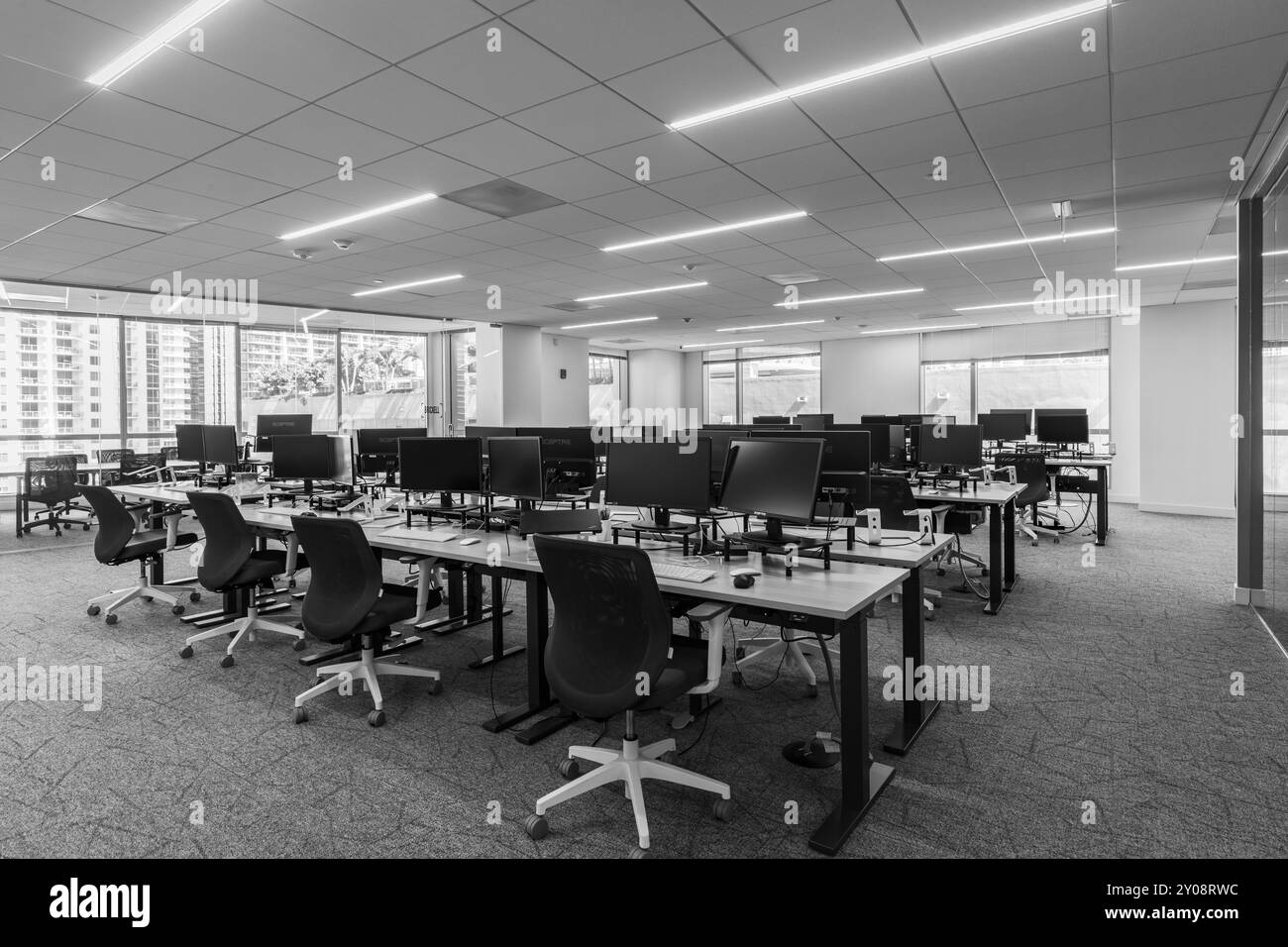 Eleganti interni per ufficio con sedie, computer e tavolo in fila vicino alla finestra, Brickell, Miami, Florida, Stati Uniti Foto Stock