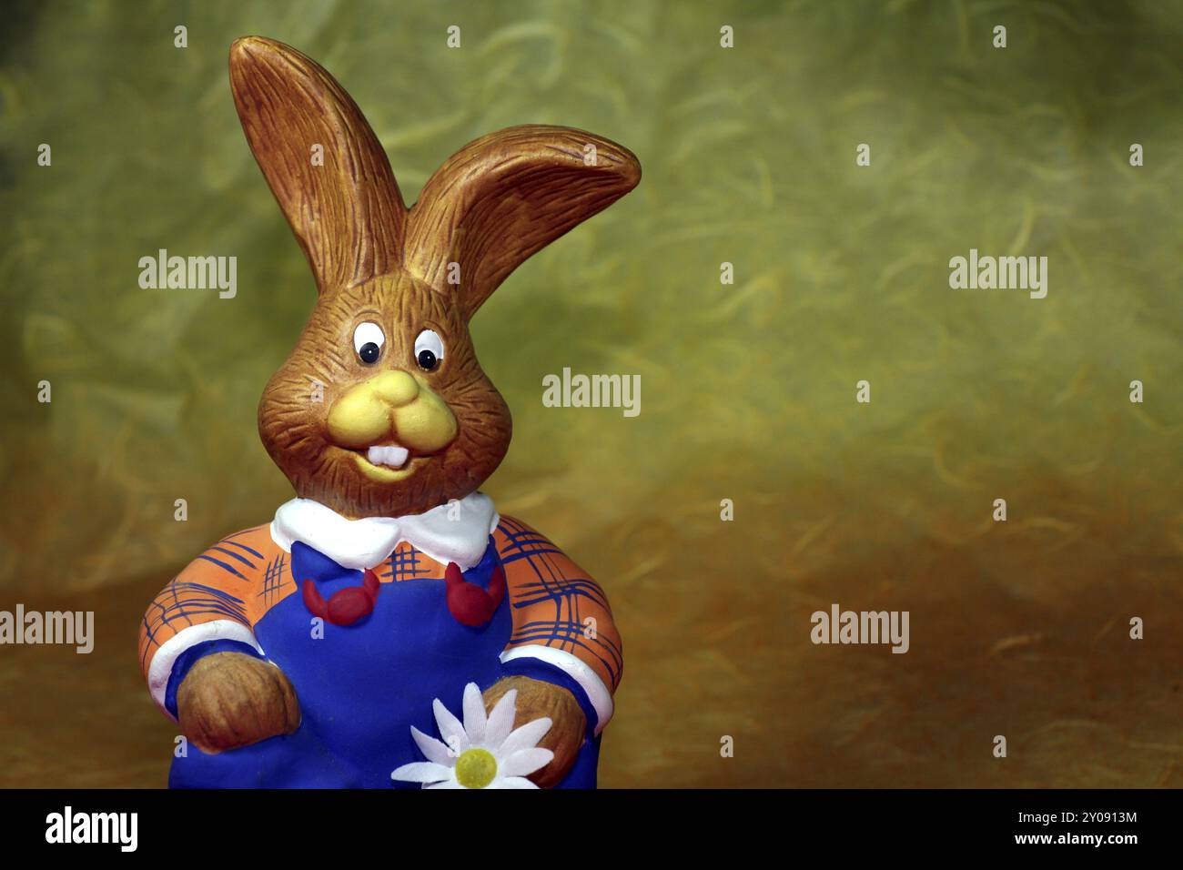 Divertente figura seduta di un coniglio con salopette blu Foto Stock