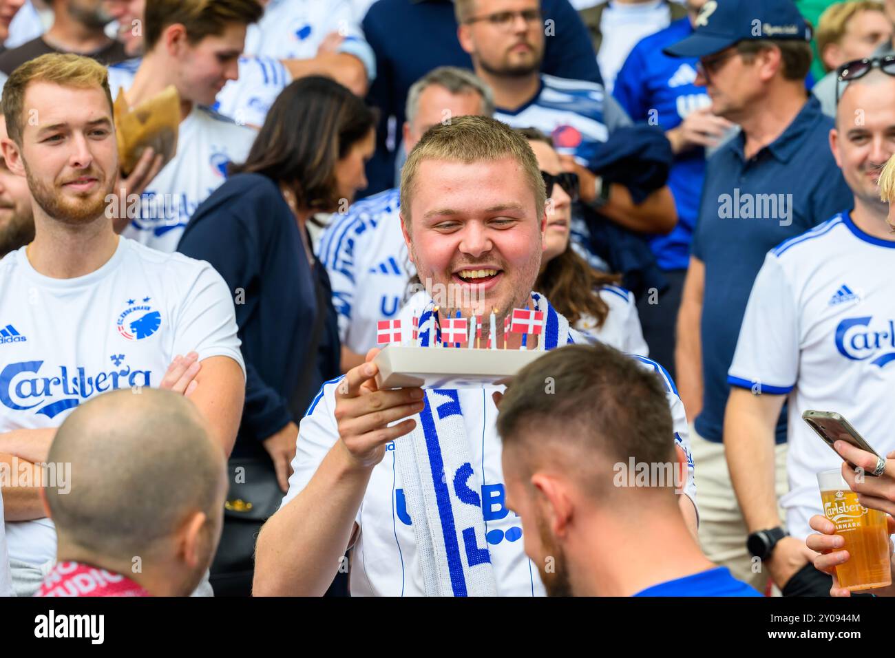 EN FCK fan har fødselsdag og vennerne har sørget for lys og flag i formentlig en stadion pølse. Superliga: FC København mod Brøndby IF - 01.09.24. Kø Foto Stock