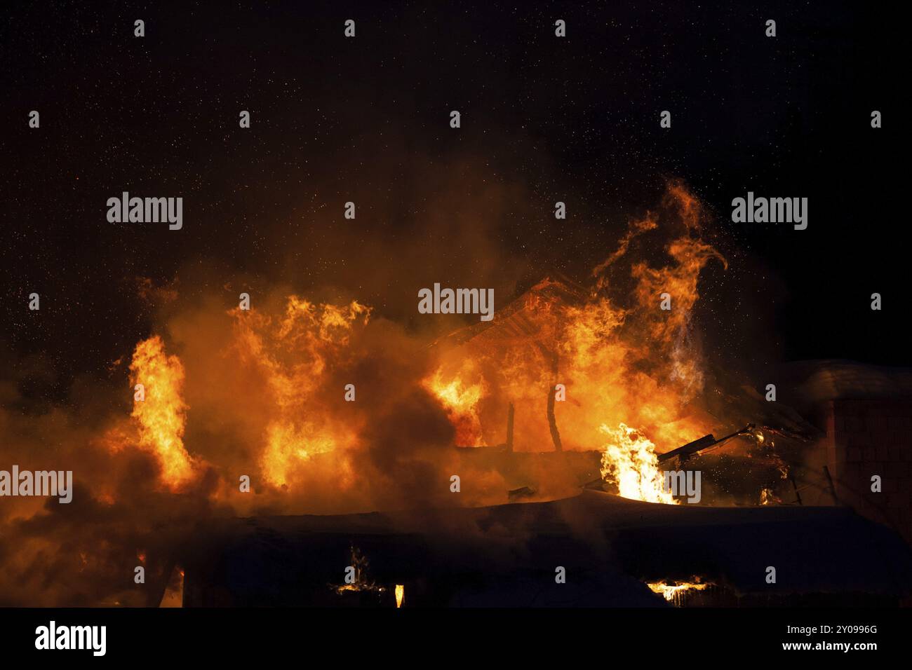 Incendio doloso o disastro naturale, fuoco incendiato sul tetto di una casa di legno Foto Stock