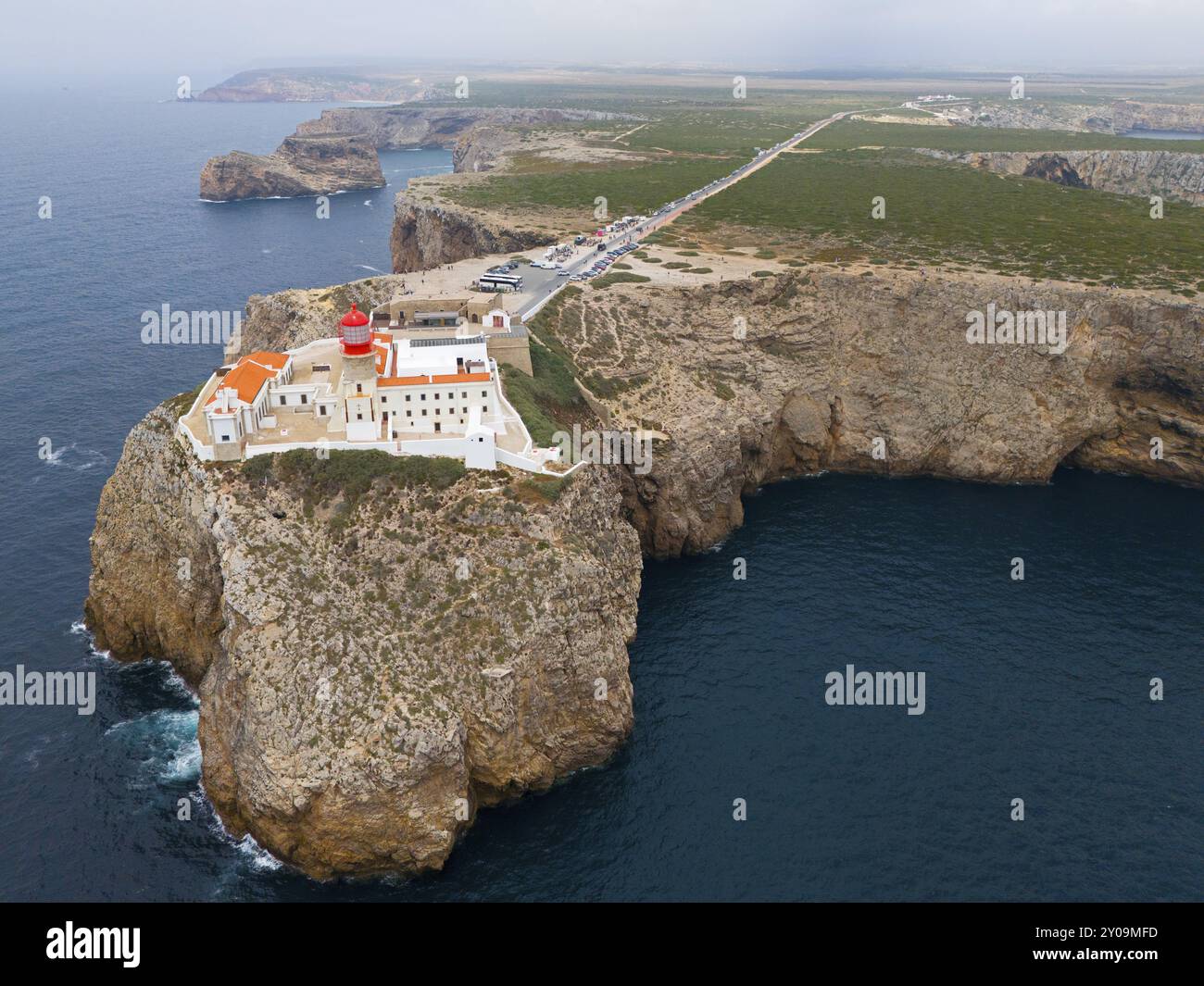 Un faro remoto e diversi edifici sorgono su una scogliera, con un'ampia vista dell'oceano e dell'area circostante, vista aerea, faro, Cabo de S. Foto Stock