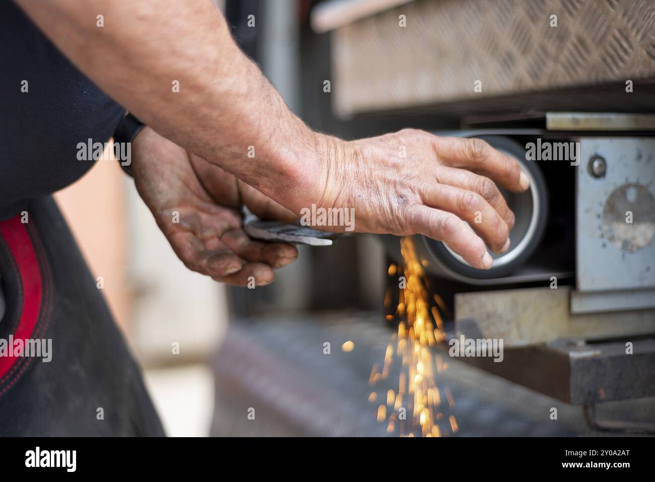 Industria della lavorazione dei metalli: Finitura della lavorazione dei metalli su una smerigliatrice orizzontale con scintille volanti Foto Stock
