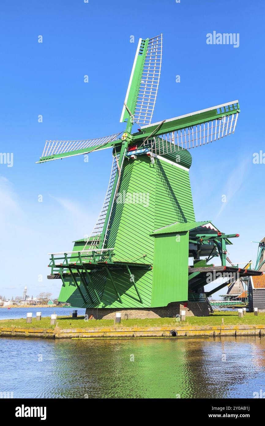 Icona di Olanda il mulino a vento di verde nel villaggio tradizionale nei Paesi Bassi contro blu cielo molto nuvoloso Foto Stock