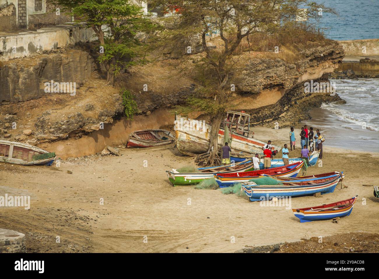 I pescatori puliscono le reti tra le loro barche sulla spiaggia Foto Stock