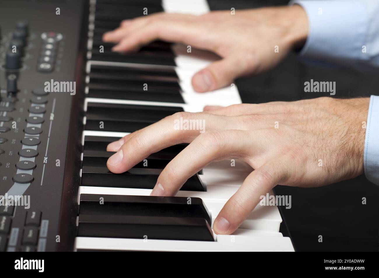 Primo piano di mani maschili che suonano il pianoforte in studio Foto Stock