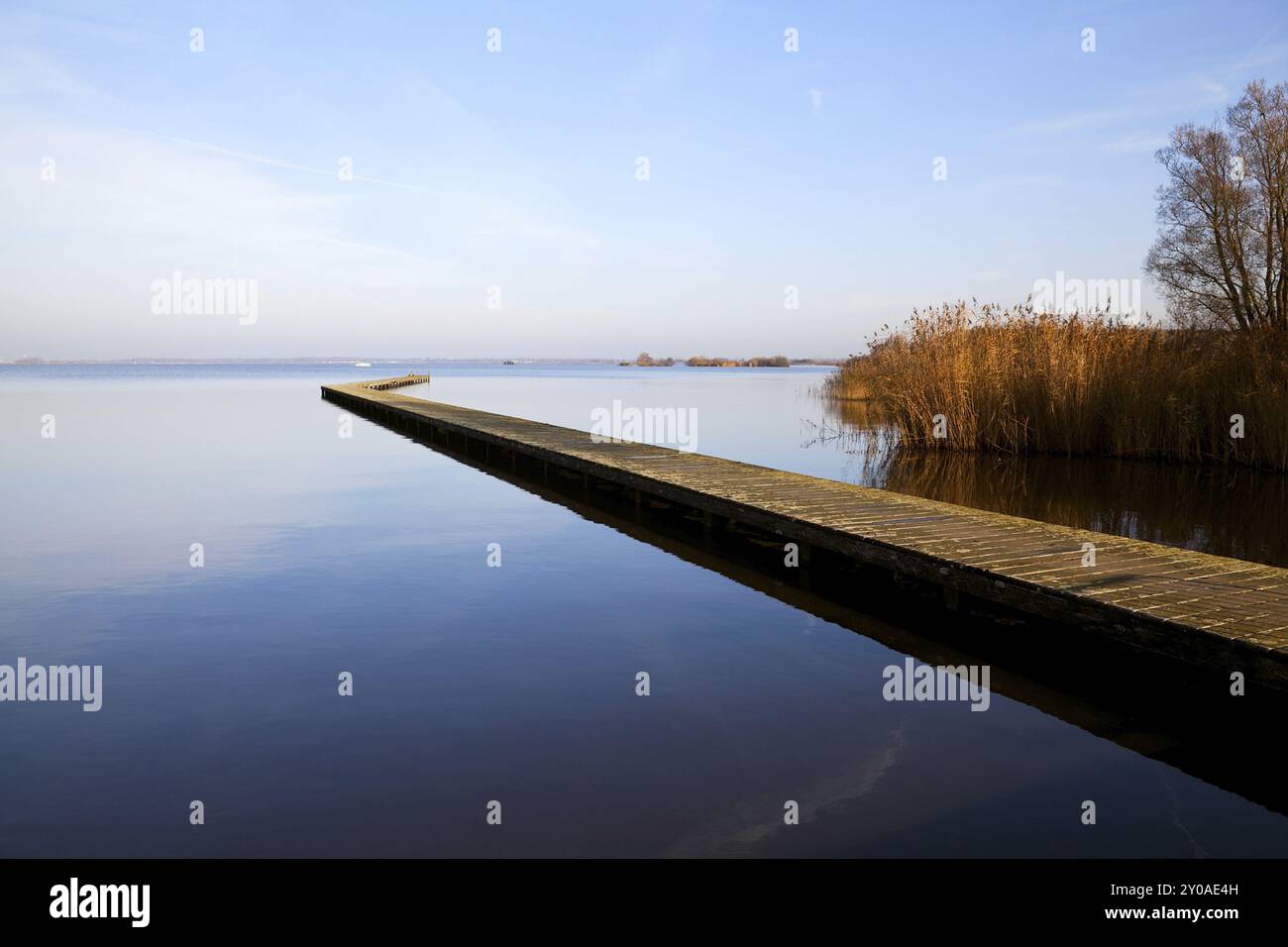 Lungo molo di legno sul grande lago blu Foto Stock