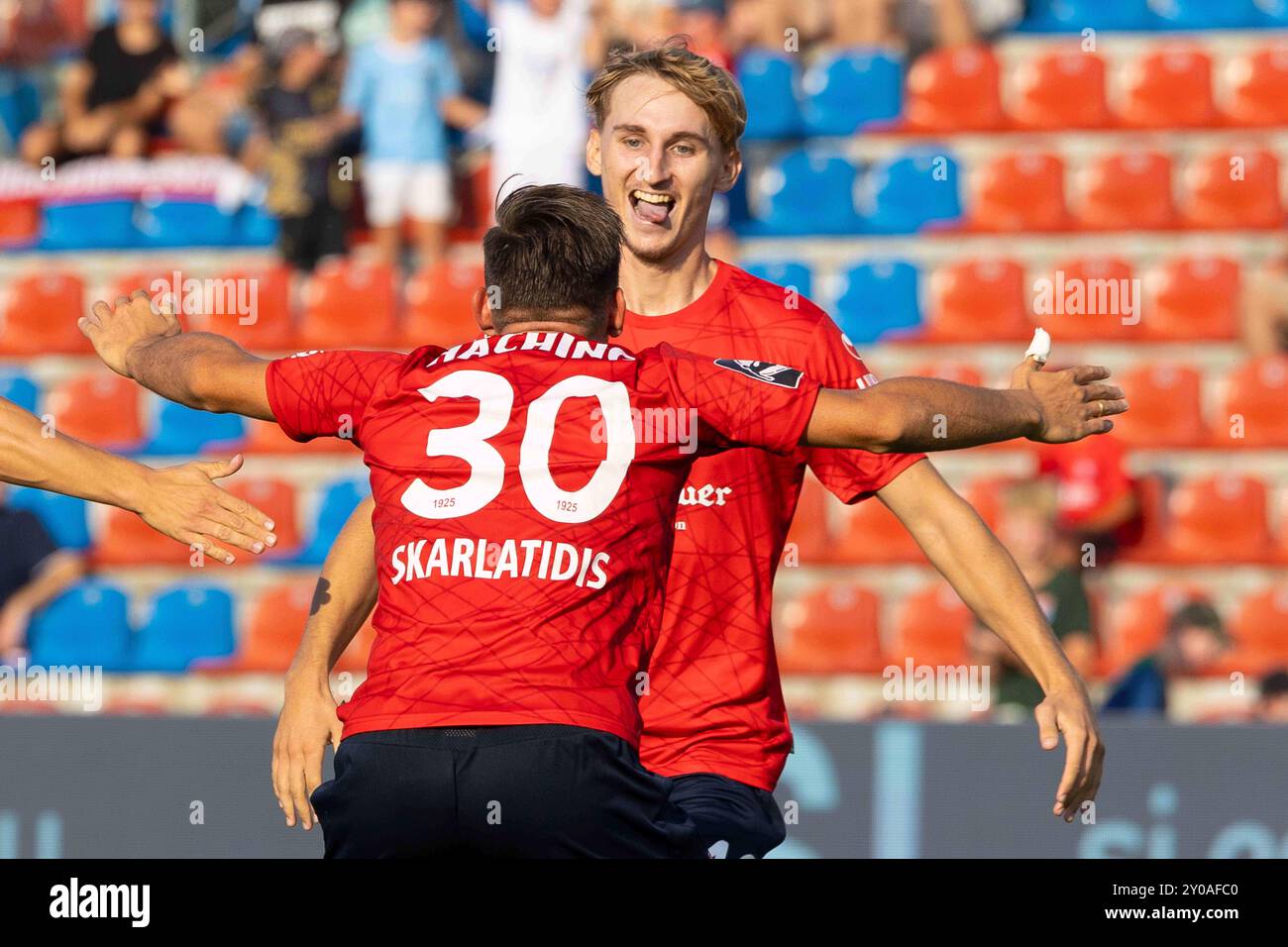 Unterhaching, Deutschland. 1 settembre 2024. Unterhaching, Germania 01. Settembre 2024: 3 . Liga - 2024/2025 - SpVgg Unterhaching vs. Rot-Weiss Essen Im Bild: im Hintergrund Torschuetze Nils Ortel (Unterhaching) jubelt nach seinem Tor zum 1:0 #mit Simon Skarlatidis (Unterhaching) // DFB regolamenti vietano qualsiasi uso di fotografie come sequenze di immagini e/o quasi-video /// credito: dpa/Alamy Live News Foto Stock