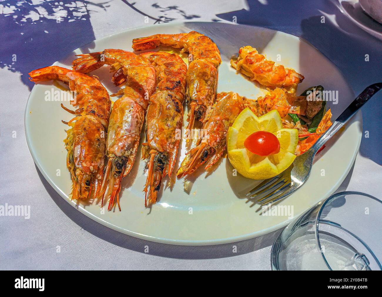 Pranzo al ristorante splendido di Bellagio. Ci siamo seduti proprio sul bordo del lago di Como. Antipasto a pranzo di gamberetti fritti (con le teste ancora attaccate nell'UE Foto Stock