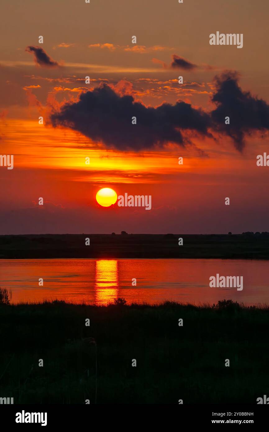Sole, che sorge sulla Lagune sull'East End di Galveston con riflessi del percorso del sole nell'acqua. Foto Stock