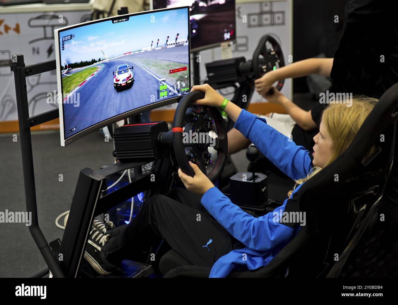 Giovane visitatore presso un simulatore di guida, la fiera Gamescom, la più grande fiera al mondo per i giochi per computer e l'elettronica di consumo, Colonia, Germania Foto Stock