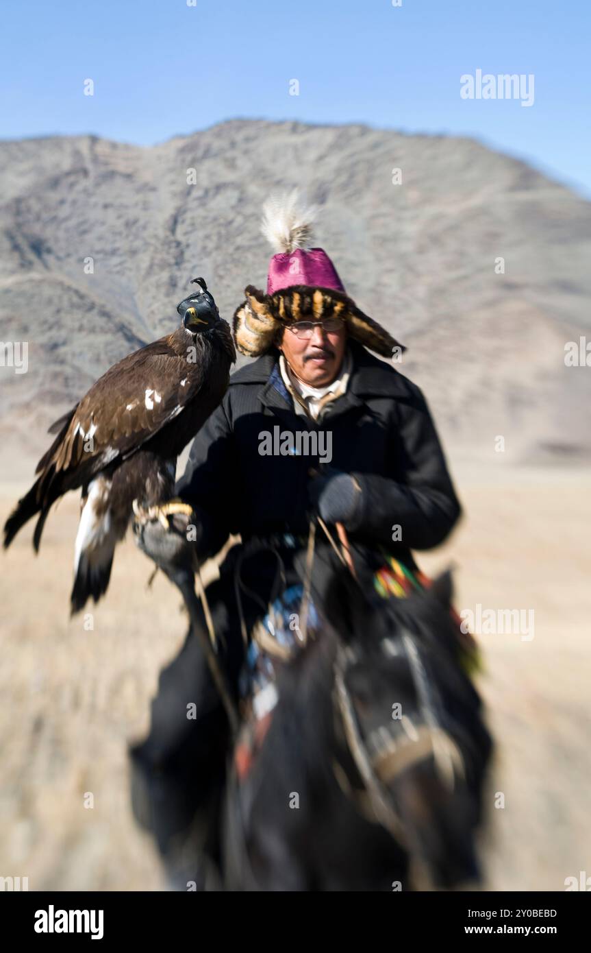 Un aquila kazaka cacciatore con il suo eagle nella regione di Altai della Mongolia occidentale. Foto Stock