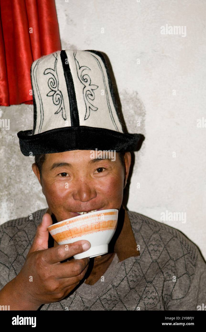 Ritratto di un uomo kirghiso scattato nella sua casa estiva presso il lago Karakul sulle montagne di Pamir nello Xinjiang, Cina. Foto Stock