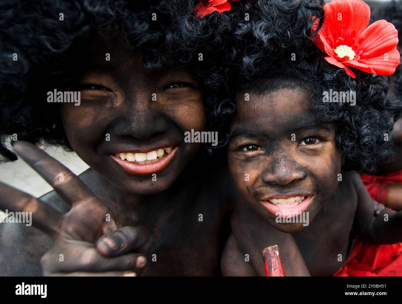 Ragazzi thailandesi con un corpo dipinto di nero e una parrucca afro durante un festival sulla strada Charoennakorn a Bangkok, Thailandia. Foto Stock