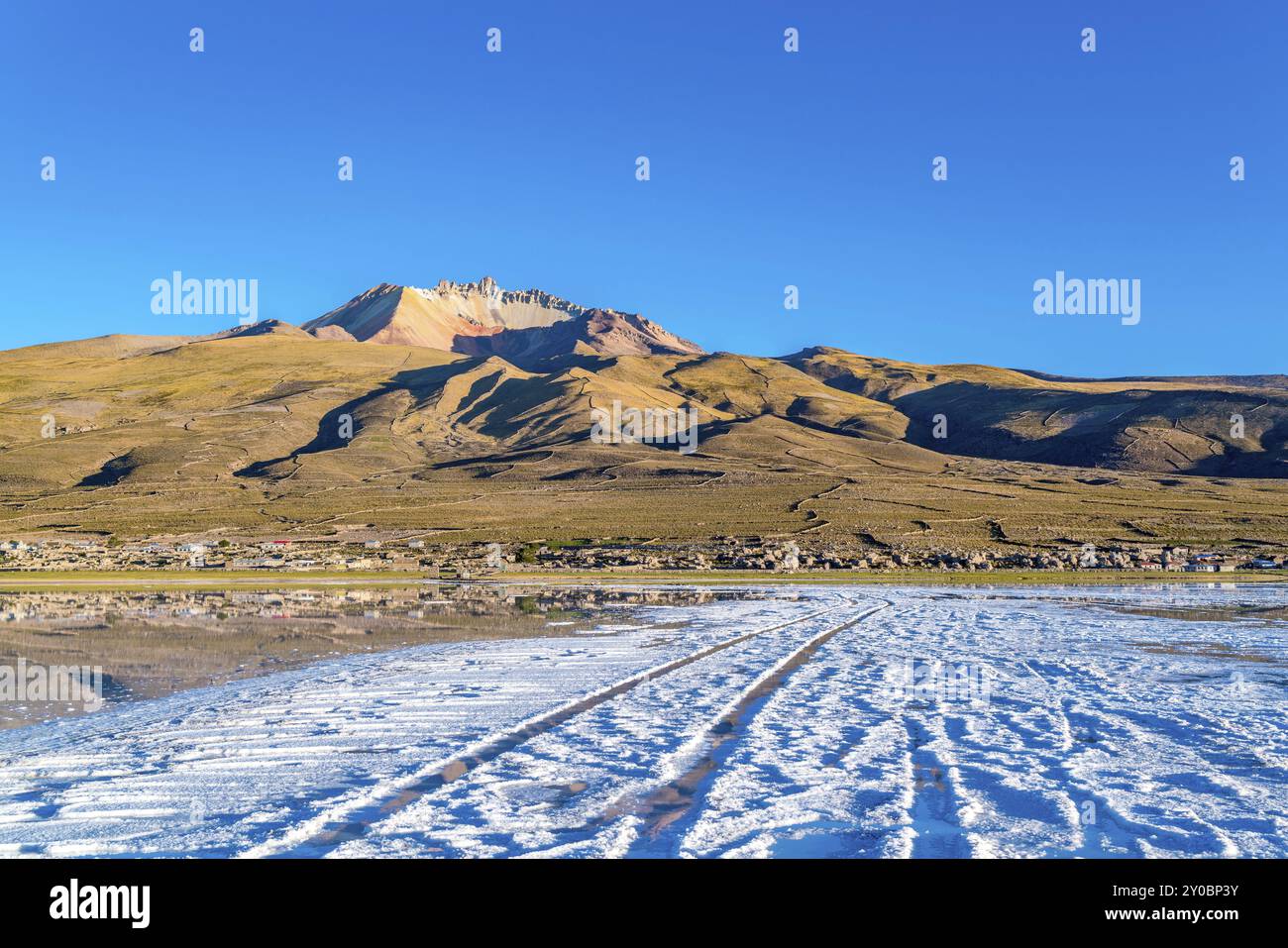 Vista del vulcano dormiente Tunupa e il villaggio di Coqueza a Uyuni distesa di sale in Bolivia Foto Stock