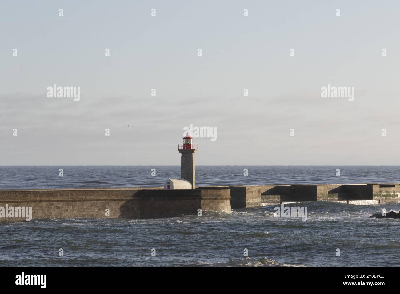 Faro Farolim de Felgueiras nell'Oceano Atlantico alla luce della sera sul lungomare di Praia do Carneiro a Foz do Douro, regione del Norte, Foto Stock