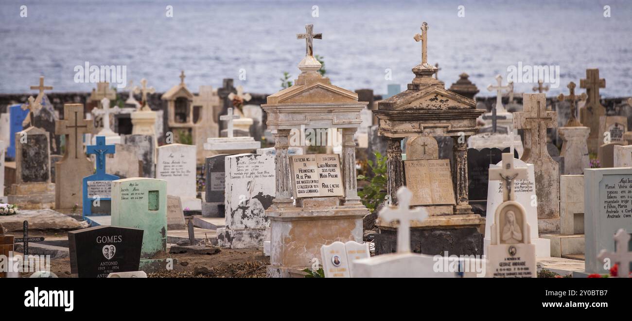 Lapidi in un vecchio cimitero cattolico con il mare sullo sfondo Foto Stock