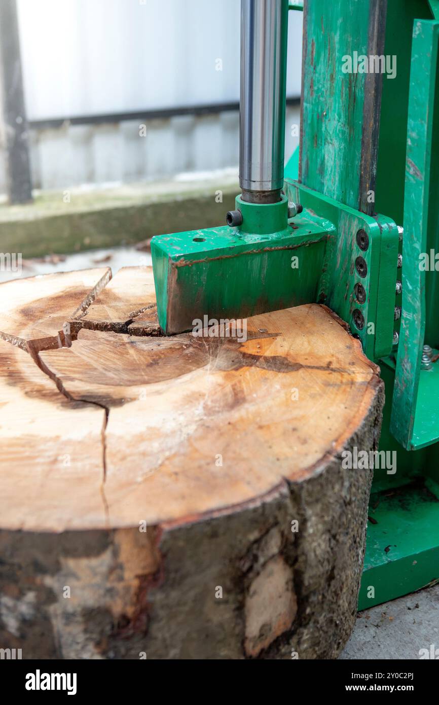 Macchina per il taglio del legno che rompe una grossa fetta di albero Foto Stock