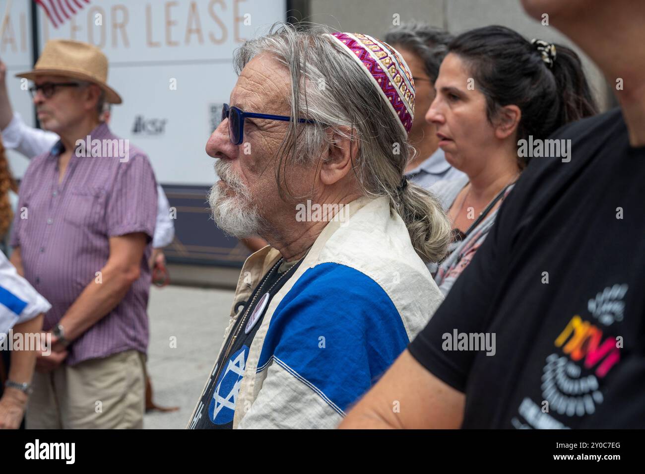 Un uomo drappeggiato con una bandiera israeliana partecipa a una veglia commemorativa per i sei ostaggi rapiti e uccisi dai terroristi di Hamas fuori dal consolato israeliano il 1° settembre 2024 a New York. Americano-israeliano Hersh Goldberg-Polin, 23 anni, su 6 ostaggi trovati morti nel tunnel di Gaza, 10 giorni dopo che i genitori hanno esortato il figlio a "rimanere forte" in un discorso del DNC. L'IDF ha identificato le altre cinque vittime come Ori Danino, 25 anni; Eden Yerushalmi, 24 anni; Almog Sarusi, 27; e Alexander Lobanov, 33; tutti rapiti dal festival musicale Nova durante l'attacco di Hamas del 7 ottobre. Il sesto, Carmel Gat, 40, W Foto Stock