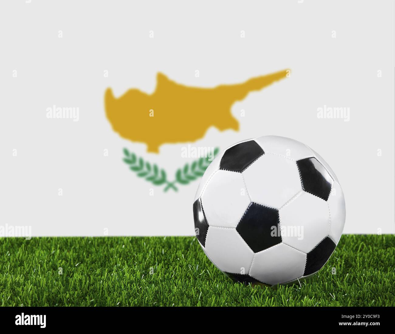 La bandiera cipriota e la palla da calcio sull'erba verde Foto Stock